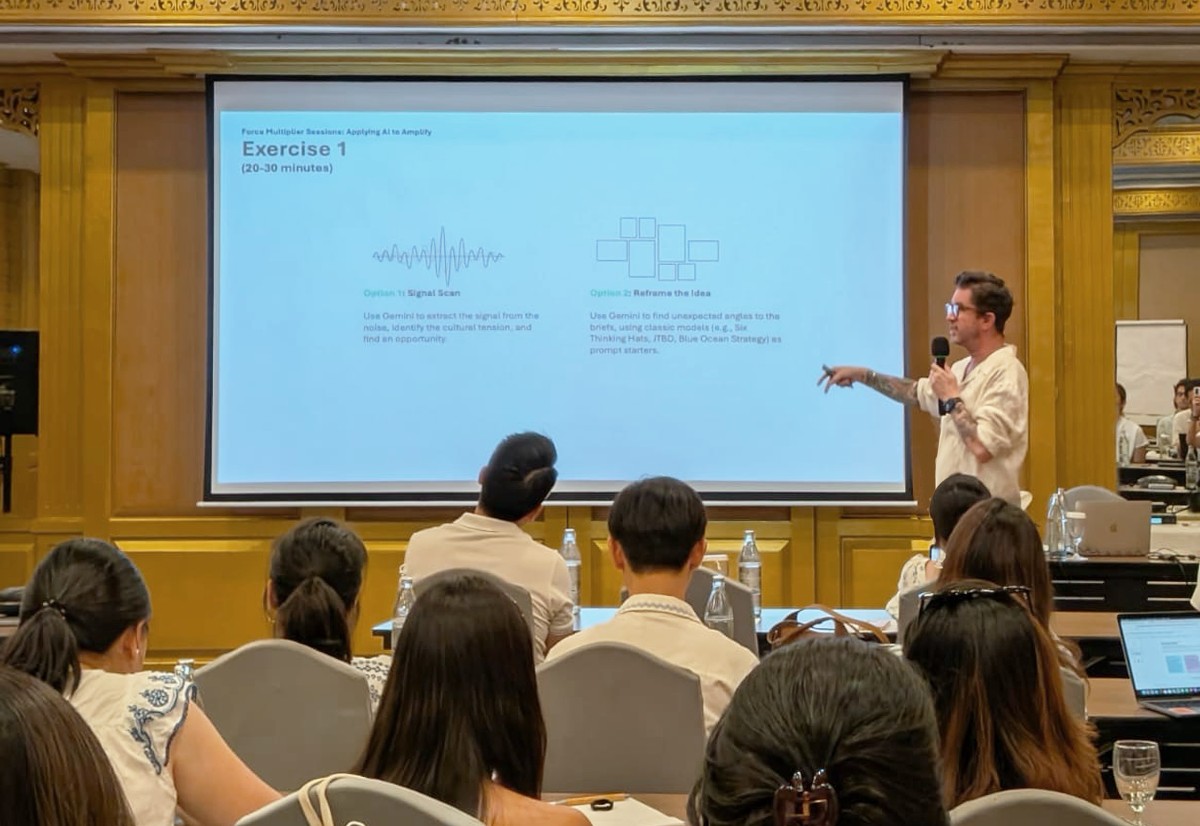 Christopher Smith leading a Force Multiplier training session, pointing to a slide about applying Gemini to creative briefs.